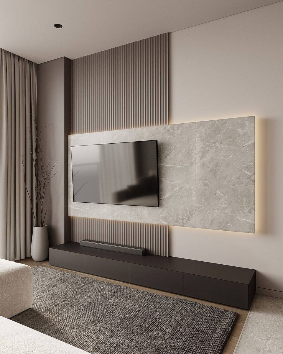 home theater em tons neutros com tapete xadrez e painel com madeira neutra escura, preta, e a tv ...